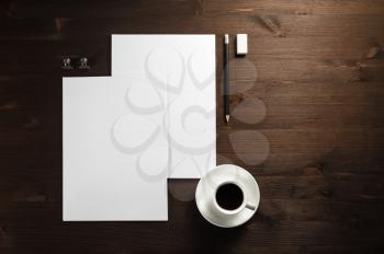 Blank branding template on wooden table background. Letterhead, coffee cup, pencil and eraser. Photo of blank stationery. Responsive design template. Space for text. Flat lay.