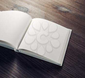 Open blank notebook on wooden background. Responsive design mockup. Selective focus.