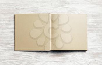 Book or brochure with blank craft paper pages on light wooden background. Mockup for placing your design. Flat lay.