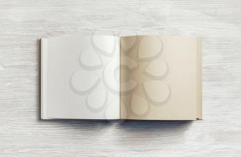 Blank kraft paper booklet on light wooden background. Responsive design mockup. Flat lay.