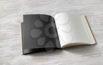 Photo of opened book with blank pages on light wooden background. Responsive design template.