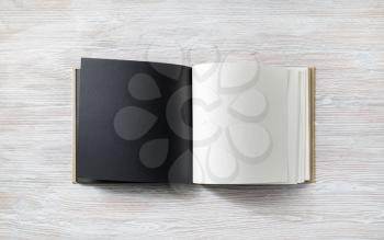 Mockup of opened blank square book on light wooden background. Flat lay.