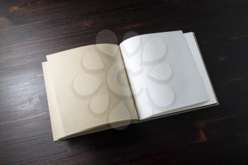 Blank open booklet on wooden background. Responsive design template.