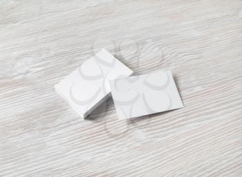 Photo of blank white business cards on light wood table background. Template for ID.