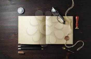 Blank kraft paper book and vintage stationery set on wooden background. Copy space for text. Flat lay.