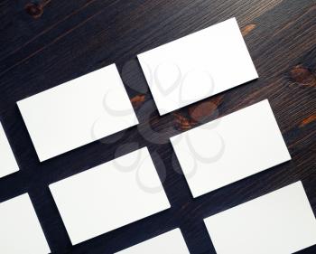 Blank white paper business cards on wood table background. Mock-up for branding ID. Flat lay.