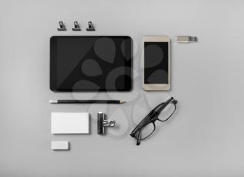 Mobile devices and blank stationery on gray paper background. Branding template. Objects for placing your design. Top view.