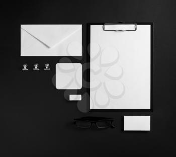 Photo of blank stationery set. Corporate identity template on black paper background. Mock up for placing your design. Responsive design mockup. Top view.