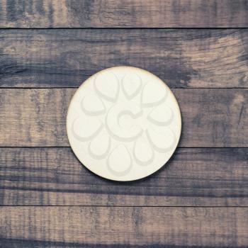 Blank wooden beer coaster on wood table background. Flat lay.