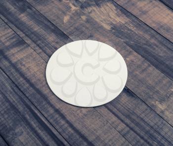 Blank white beer coaster on wooden background.