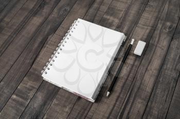 Blank notepad, pencil and eraser on vintage wood background.