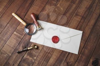 Vintage envelope and stationery: wax seal, magnifier and spoon on wooden background. Responsive design mockup.