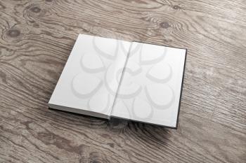 Mockup of opened blank book on wood table background. Responsive design mockup.