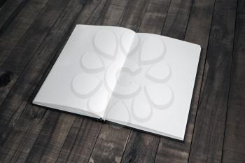 Blank open book on vintage wood table background. Responsive design mockup.