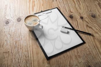 Clipboard with blank letterhead, coffee cup, pencil and sharpener on wood table background. Mock up for placing your design
