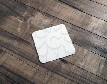 Photo of square beer coaster on wooden background. Blank template for your design.
