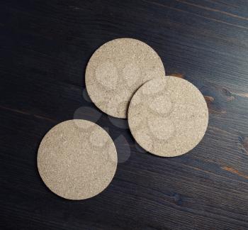 Photo of blank cork beer coasters on wooden background. Flat lay.