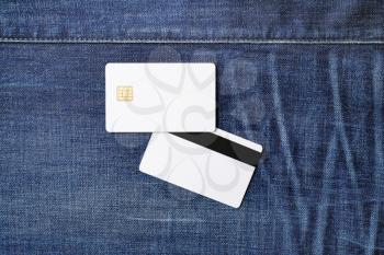 Two blank credit cards on denim background. Chip cards. Mockup for branding identity. Template for graphic designers portfolios. Flat lay.
