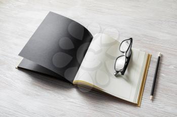 Photo of open book with blank pages, glasses and pencil on light wooden background. Responsive design template.