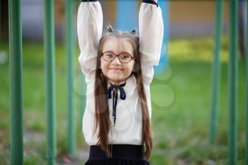 Happy child girl on the playground. Schoolgirl having fun on the playground. Selective focus.