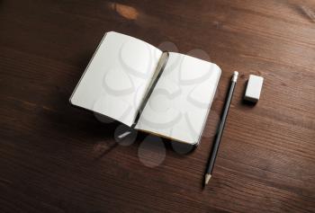Blank notebook, pencil and eraser on wooden background. Responsive design mockup. Blank objects for placing your design.