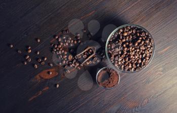 Roasted coffee beans and ground powder on wood kitchen table background. Flat lay.