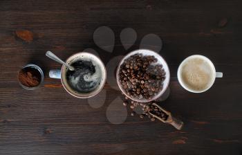 Espresso, coffee cup, coffee beans and ground powder on wood table background. Top view. Flat lay.