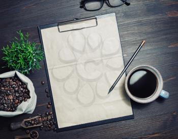 Menu and coffee. Clipboard with blank kraft letterhead, coffee cup, plant, coffee beans and pencil on wooden background. Top view. Flat lay.