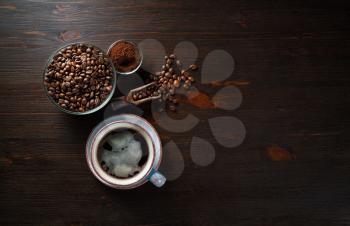 Vintage coffee background with space for text. Still life with cups of coffee, coffee beans and ground powder on wood table background. Flat lay.