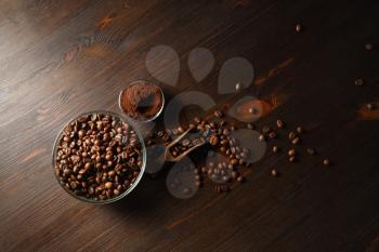 Coffee beans and ground powder on wooden background. Top view. Flat lay.