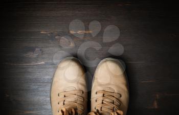 Shoes for travel. Travel boots on brown wood floor background. Copy space for your text. Flat lay.