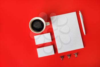 Photo of blank stationery set on red paper background. Corporate identity template. Responsive design mockup. Flat lay.