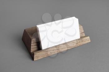 Photo of blank business cards on wooden card holder. Placing your design.