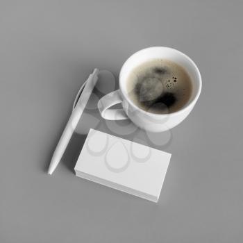 Branding mock up. Photo of blank business cards, coffee cup and pen on gray background.