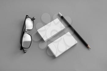 Blank stationery mockup. Business cards, pencil and glasses on gray paper background. Brand ID set.