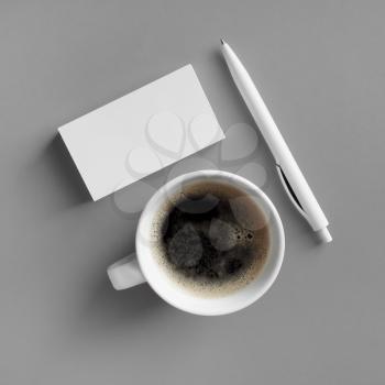 Blank stationery and coffee cup on gray background. Responsive design mockup. Flat lay.