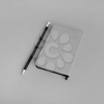 Blank notepad and pencil on gray paper background. Template for branding design.
