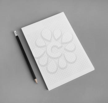 Branding stationery mockup. Copybook and pencil on gray paper background. Blank objects for placing your design.