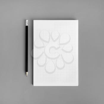 Blank copybook and pencil on gray paper background. Branding ID template. Flat lay.