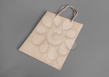 Blank craft paper bag on gray background. Responsive design mockup.