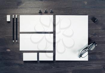 Photo of blank corporate stationery on wood table background. Branding mock-up. Top view. Flat lay.