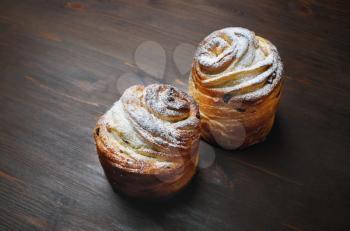Two delicious sweet buns on wooden background,