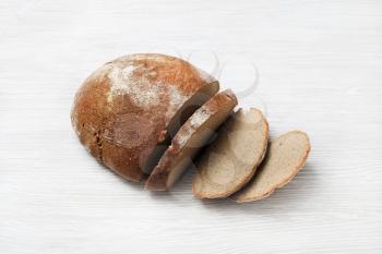 Sliced fresh bread on light wooden background.