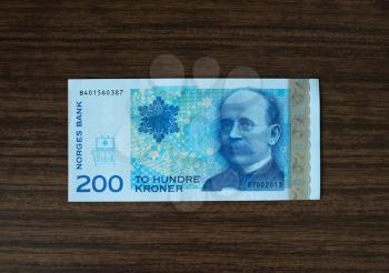 200 Norwegian krones face on wood desk background hd