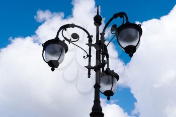 Vintage lamp on blue sky with clouds background