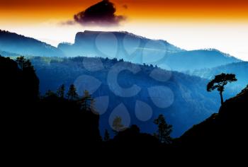 Horizontal vdramatic mountain trees on rocks silhouette sunset background backdrop