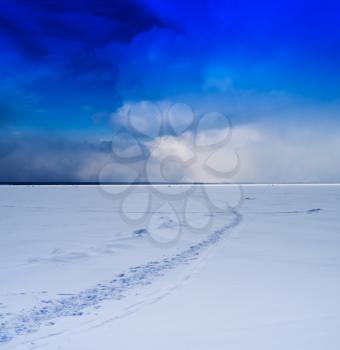 Square vivid winter morning on frozen lake footprints path cloudscape background backdrop