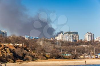 Odessa, Ukraine 12.04.2019. View from the sea to the big smoke from a burning house in Odessa on a sunny winter day