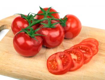 Fresh tomatoes and  tomatoes slices on a hardboard 