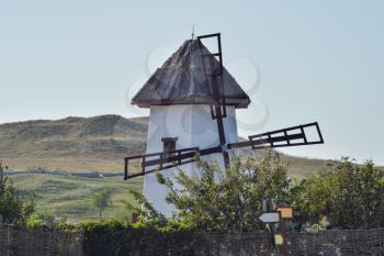 Old stone mill with a thatched roof. Mill on the background hills.